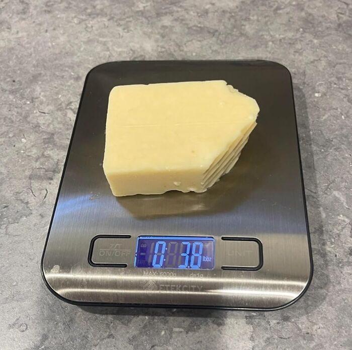 A block of cheese on a digital kitchen scale showing 10.38 ounces, featured in The 40K Review Club selection.