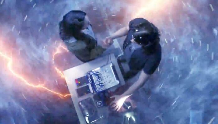 Two filmmakers creatively using props to simulate a sci-fi scene with special effects and lighting.