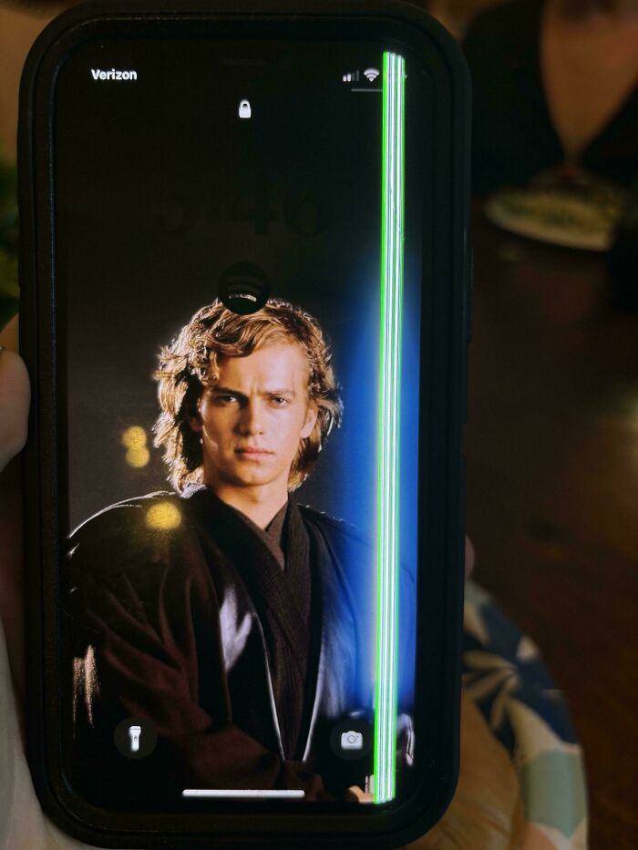 A phone screen with character image and a vertical display error, highlighting a failed repair attempt.