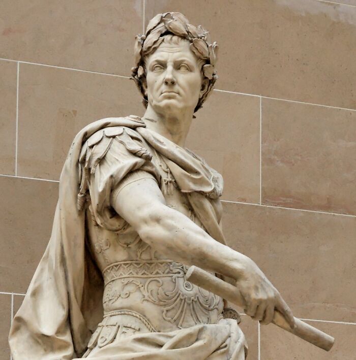 Marble statue of a Roman Emperor in elaborate armor, showcasing Roman Empire grandeur.