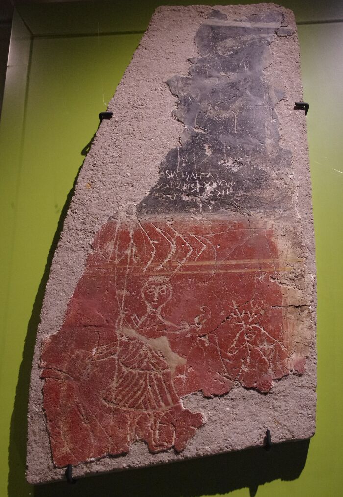 Ancient Roman Empire fresco depicting a warrior, displayed on a green background, illustrating historical art.