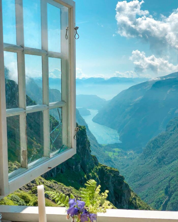 Open window view of a stunning mountainous landscape with a river below, capturing a beautiful place.