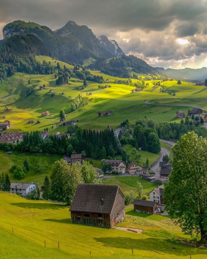 Sunlit valley with scattered houses and lush greenery, showcasing one of the most beautiful places discovered.