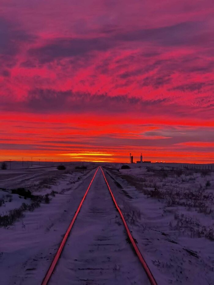 Stunning sunset over snowy railroad tracks, showcasing one of the most beautiful places discovered.