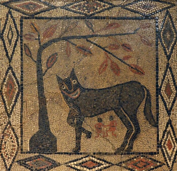 Ancient Roman mosaic depicting a wolf under a tree with geometric patterns.