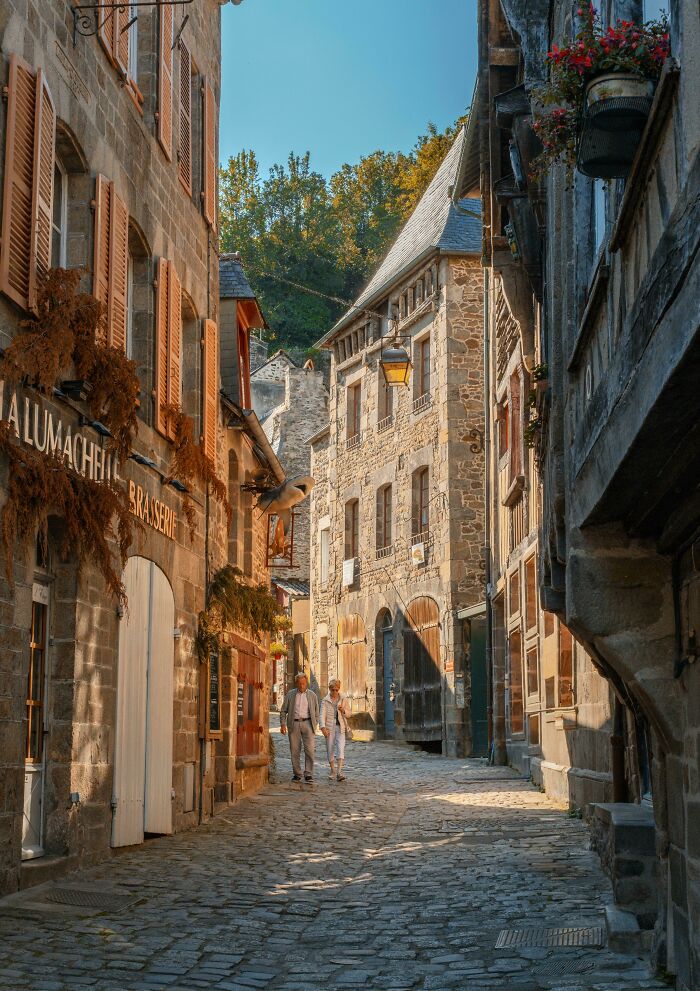 Old cobblestone street lined with charming stone buildings and plants. Quiet, picturesque scene of a beautiful place discovered.