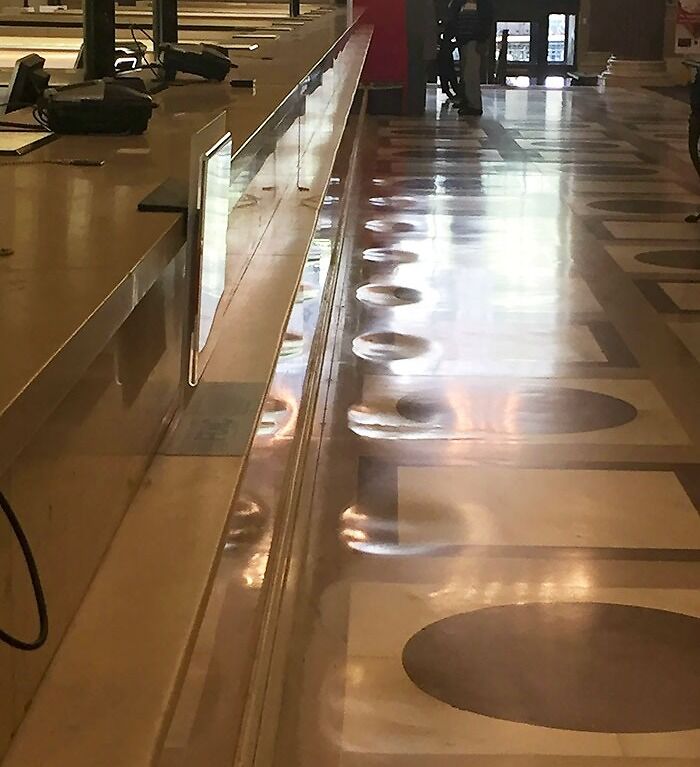 Worn floor tiles showing years of use and transformation by time in a public space.