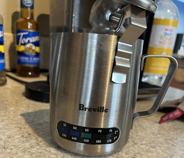 Stainless steel Breville milk frother with temperature gauge, a genius kitchen find for coffee lovers.