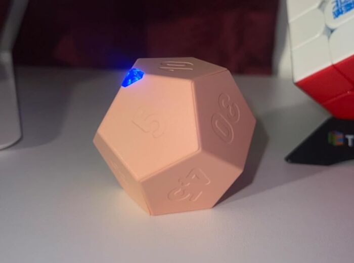 Pink 20-sided kitchen timer with glowing blue light on a table, highlighting a genius kitchen find.