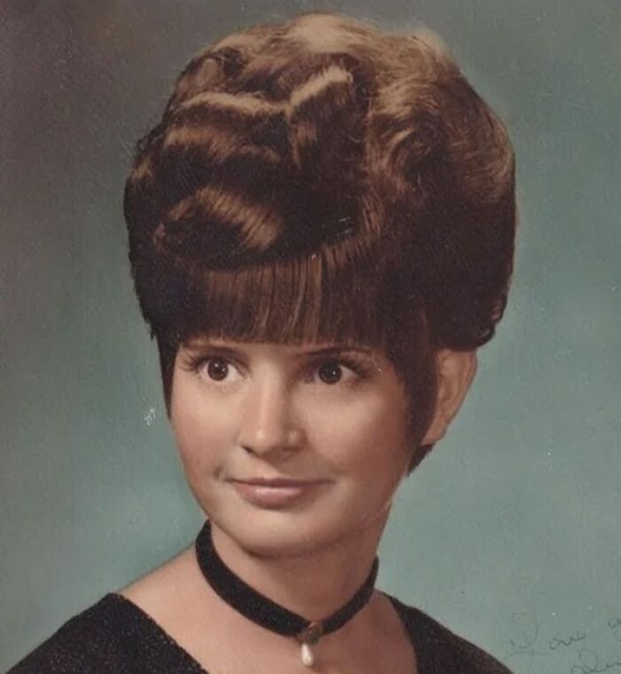 Vintage hairstyle featuring an intricate updo and bangs, embodying the unique fashion from yesteryear.