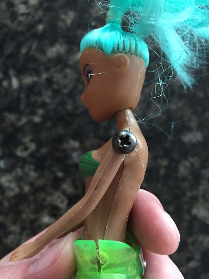 Doll with turquoise hair and improvised s***w shoulder, showcasing elderly humor creativity.