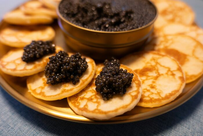 A plate of blini topped with caviar, showcasing a top dish from different countries.