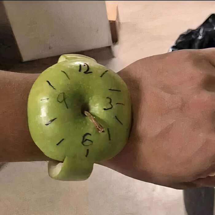 Green apple wristwatch, with drawn numbers, showcasing funny random image creativity.