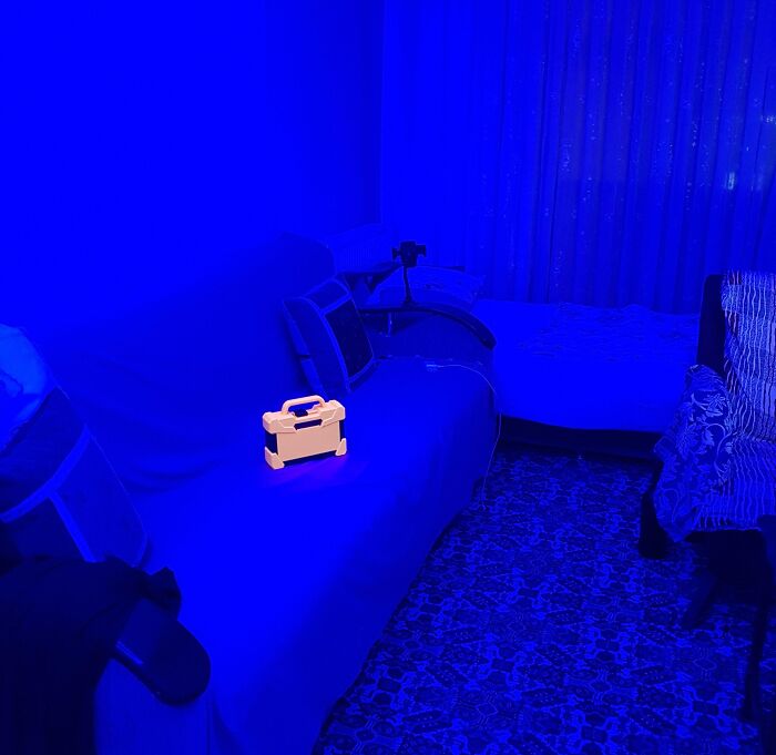 Vibrant blue room with an illuminated yellow toolbox, creating a surreal and intriguing scene.