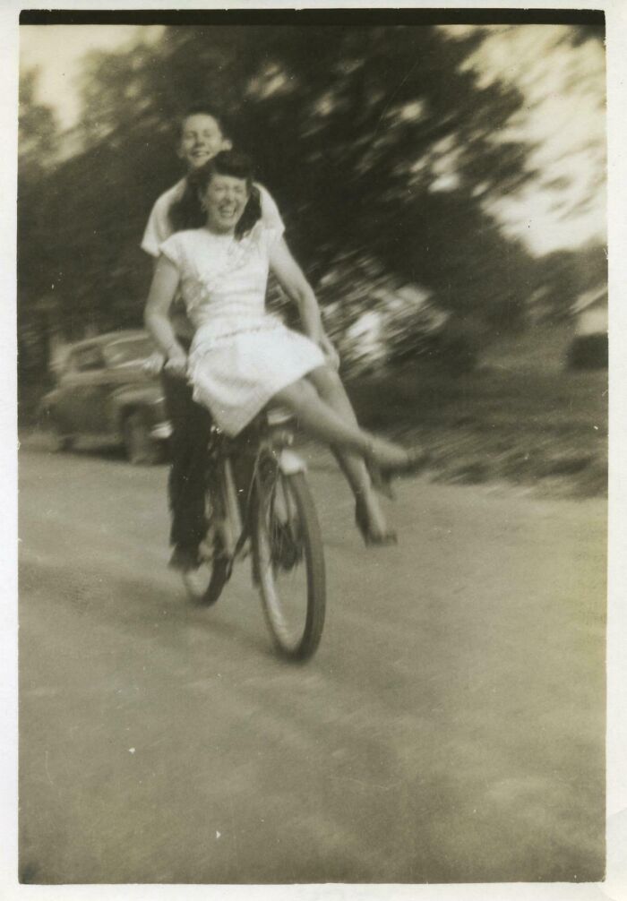 Vintage photo of a joyful couple riding a bicycle together showing fascinating old images from history.