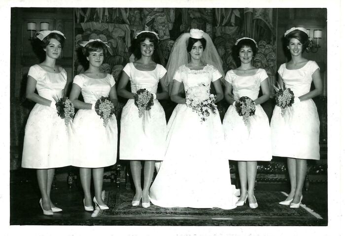 Black and white vintage wedding photo with bride and bridesmaids holding bouquets in old images history collection.