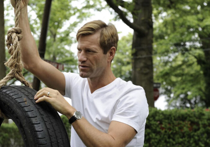 Actor preparing a scene by holding a tire swing outdoors, showcasing dedication to difficult roles in acting.