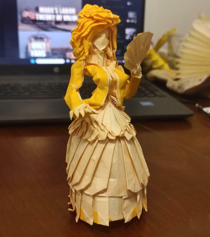 Origami figure resembling a woman in a dress, appearing almost unreal but truly authentic.