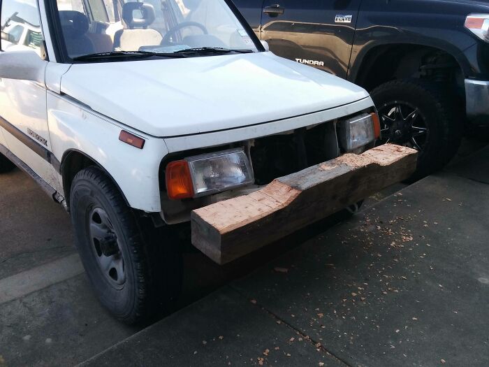 A white car with a humorous makeshift wooden bumper, showcasing the creativity of funny coworkers.