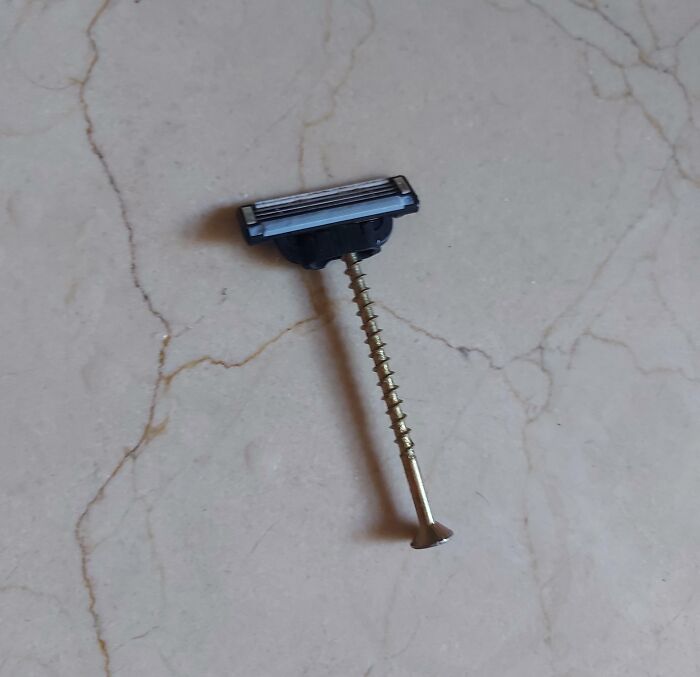 Failed repair using a razor head attached to a s***w on a marble surface.