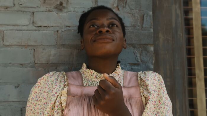 Person smiling softly, wearing a floral dress, evoking an emotional moment in a film known to cause tears.