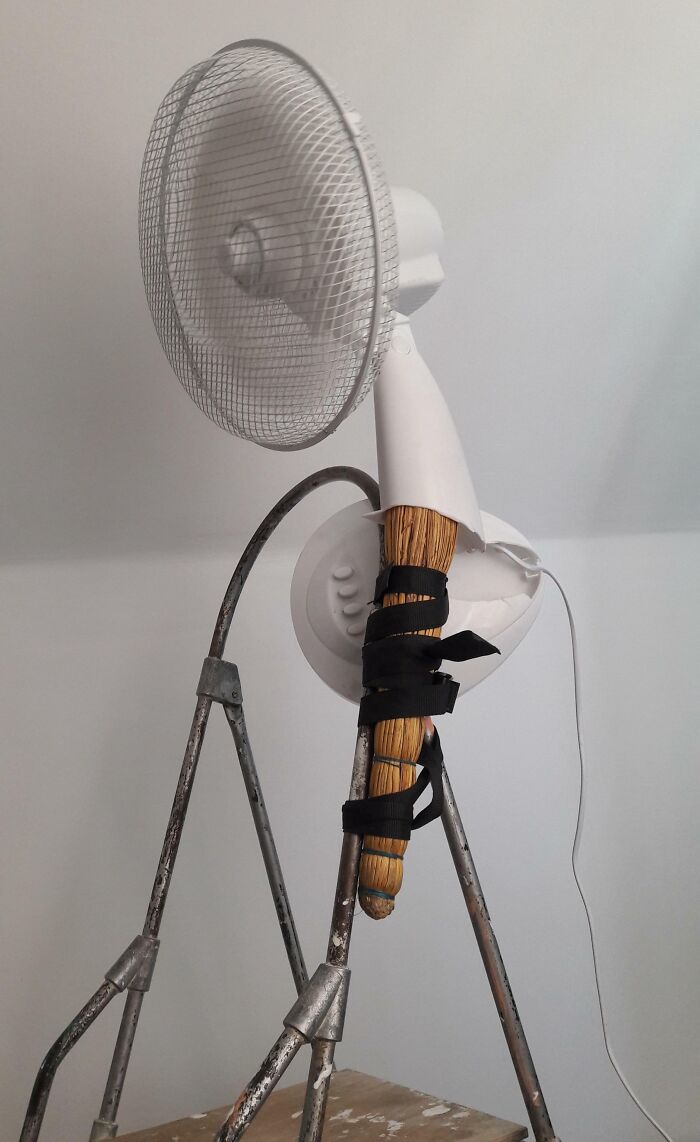 Failed repair attempt with a fan attached to a broom on a ladder.