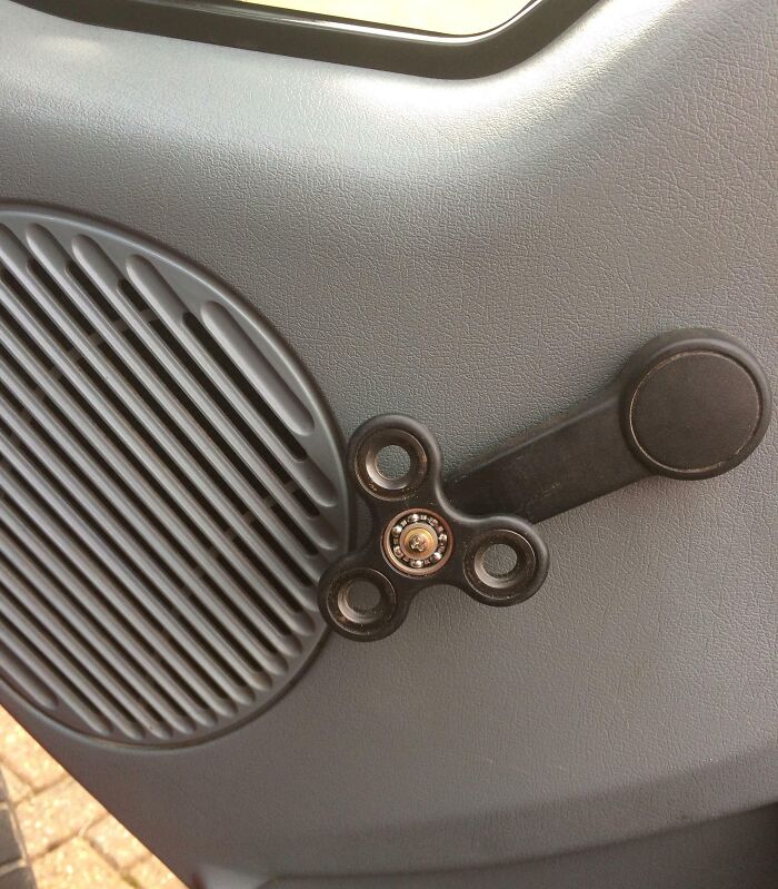 Car repair fail with a fidget spinner used as a window crank handle replacement.