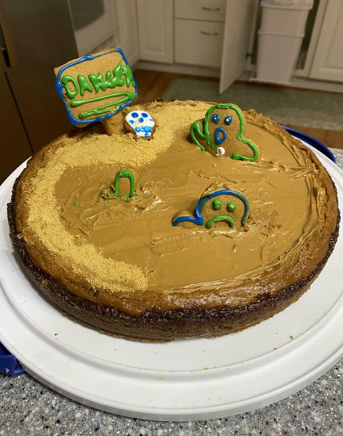 Humorous coworkers' cake with playful icing decorations and a "Danger" cookie sign.