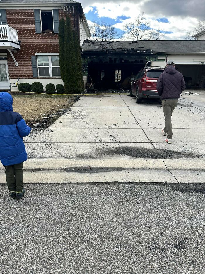 House with burned garage and two people observing the damage, illustrating online frustration over unexpected events.