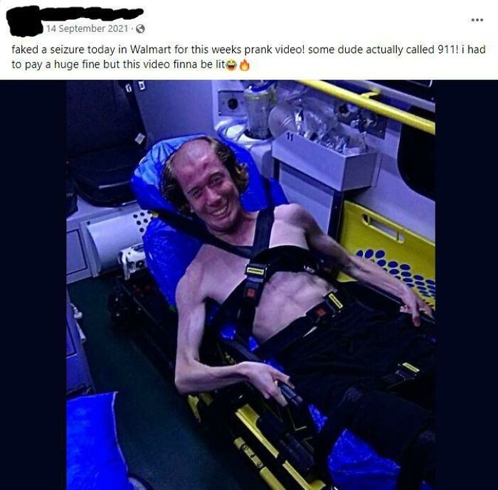 Man strapped to a gurney in an ambulance, smiling broadly after a prank gone wrong, showcasing online outrage.