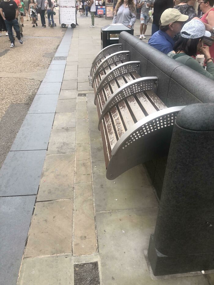 People expressing anger online; image shows an unusual bench design on a busy city street.