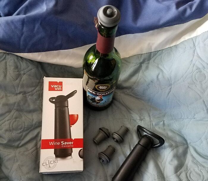 Wine saver with bottle and accessories on bed, ideal backup for solo living.