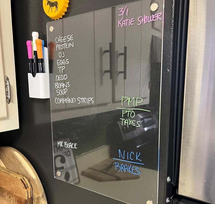Dry erase board with colorful markers displaying notes and reminders for solo living essentials.