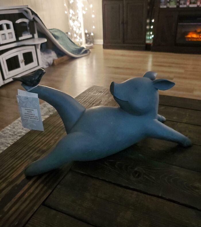 Humorous pig figurine holding a bird on its foot, adding a quirky touch to the living room decor.