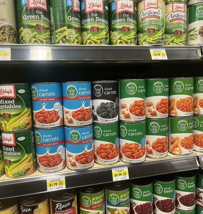 Canned vegetables aisle with mismatched sliced carrots labels, appearing fake but real.