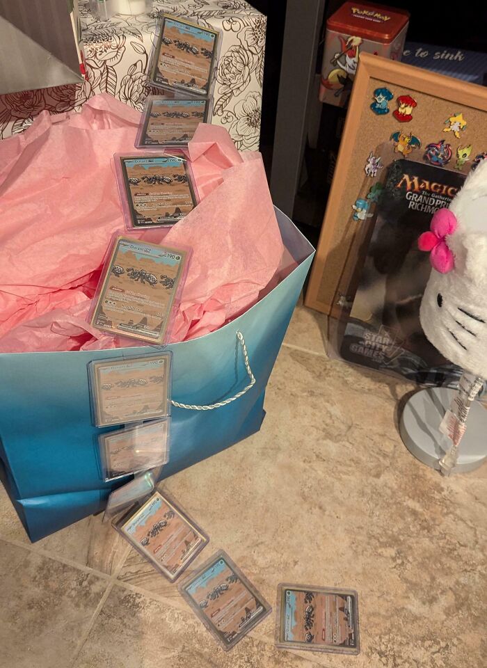 Trading cards spill from a gift bag, creating a playful scene on the floor, emphasizing a fun partner's surprise.