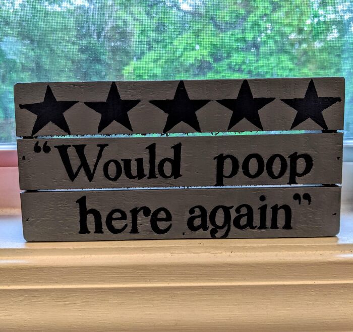 Five-star wooden sign with the humorous text "Would p**p here again," showcasing a funny perspective.