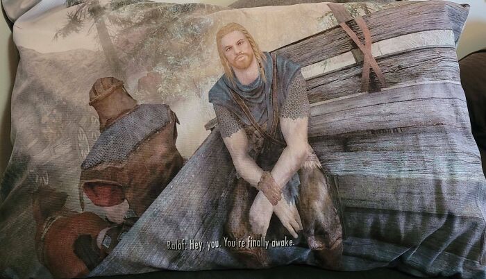 Hilarious man ensures partner's life is exciting with a pillow featuring a game character and humorous quote.