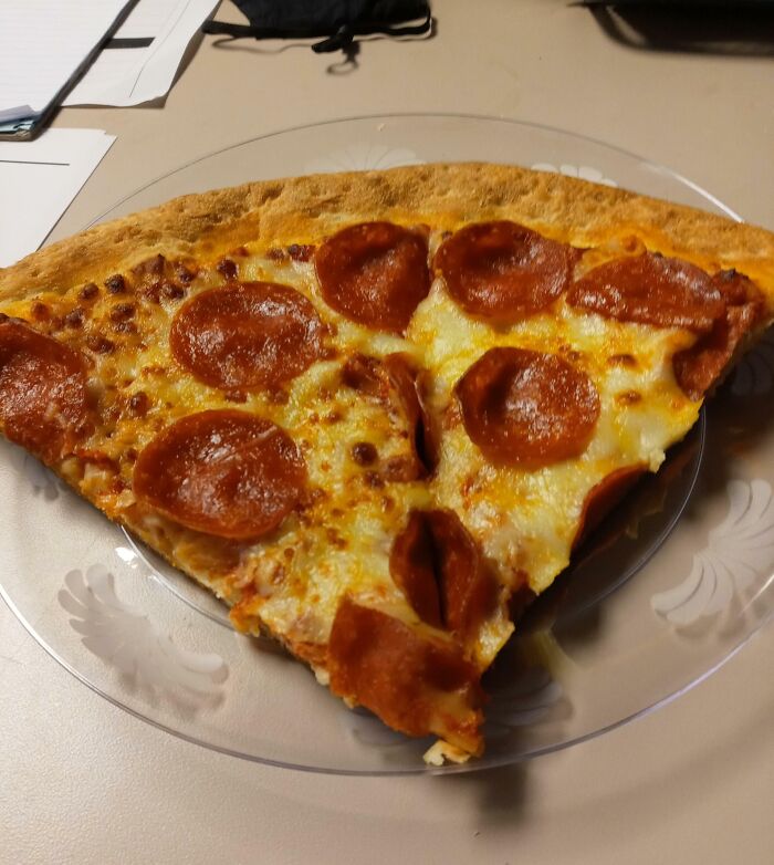 A slice of pepperoni pizza on a clear plate, representing a boss featured in the hall of shame for infuriating superiors.