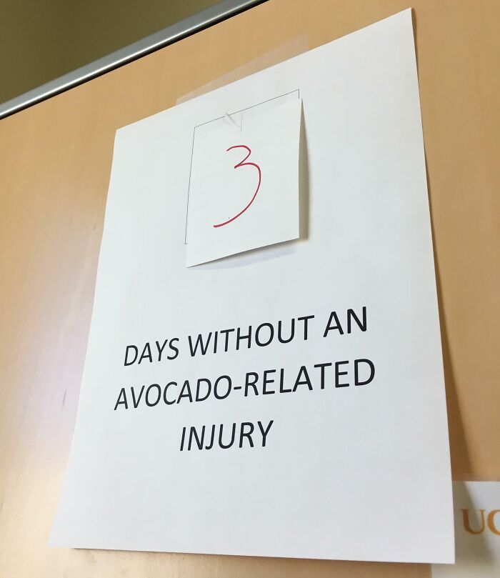 Funny coworkers display a sign showing 3 days without an avocado-related injury.