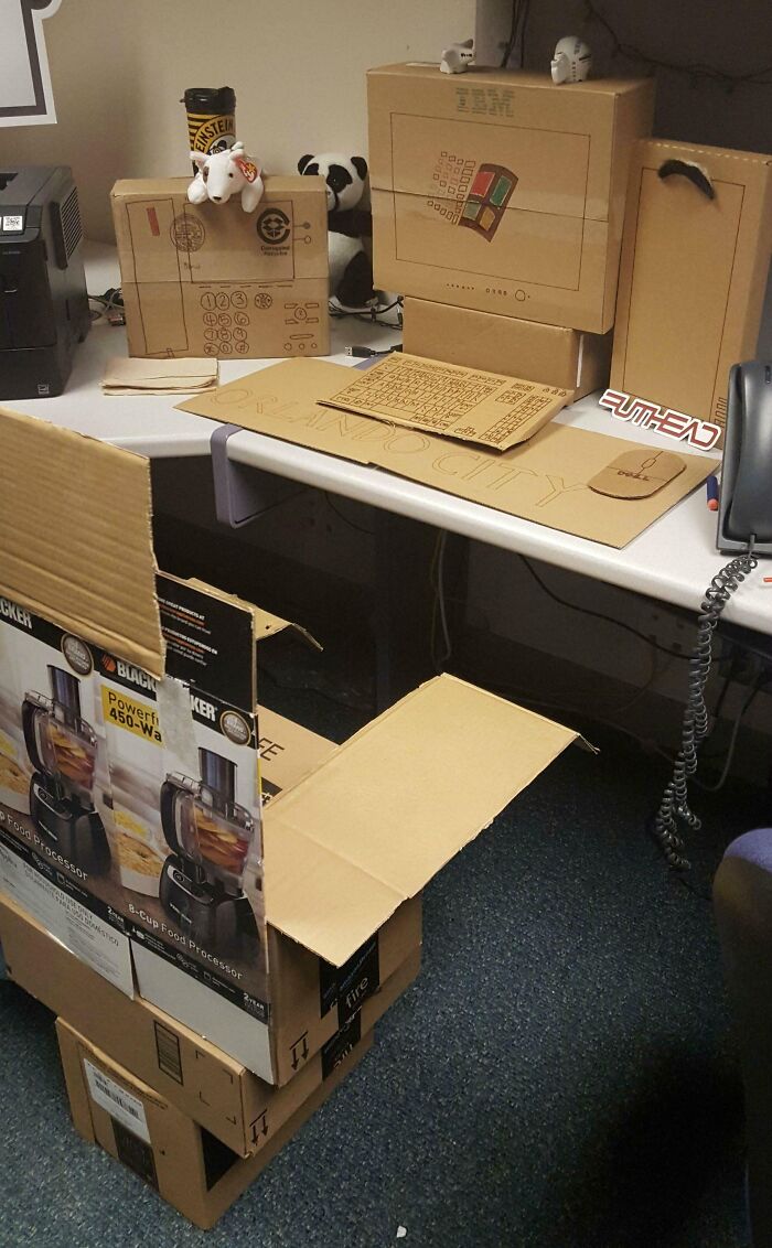 Cardboard office setup showing humorous coworkers' creativity.