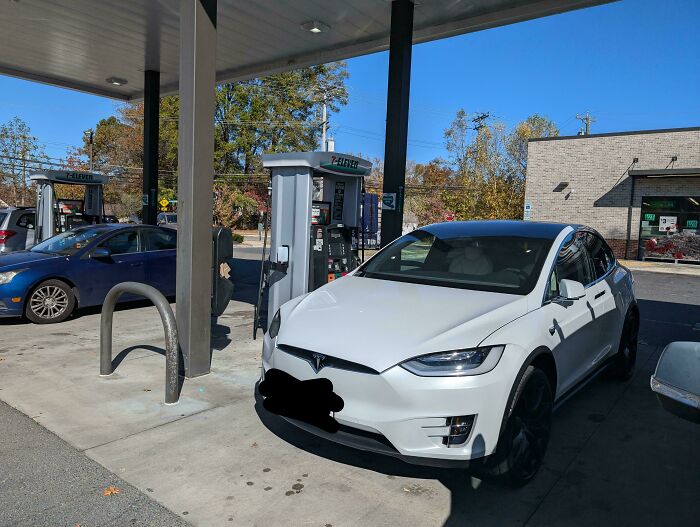 Tesla at gas station, highlighting lack of basic etiquette in online shaming context.