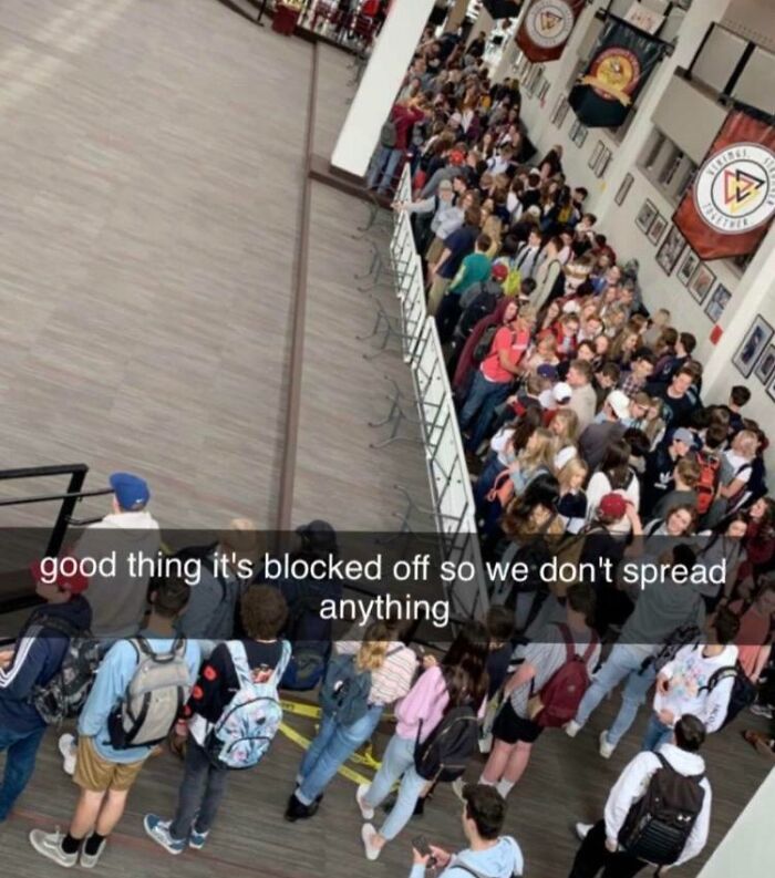 Students crowded in a hallway of an American school, with barriers blocking off part of the floor space.