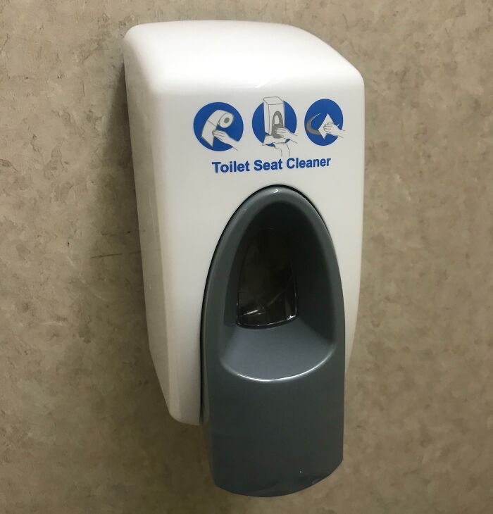 Toilet seat cleaner dispenser in an American school bathroom, highlighting amenities.
