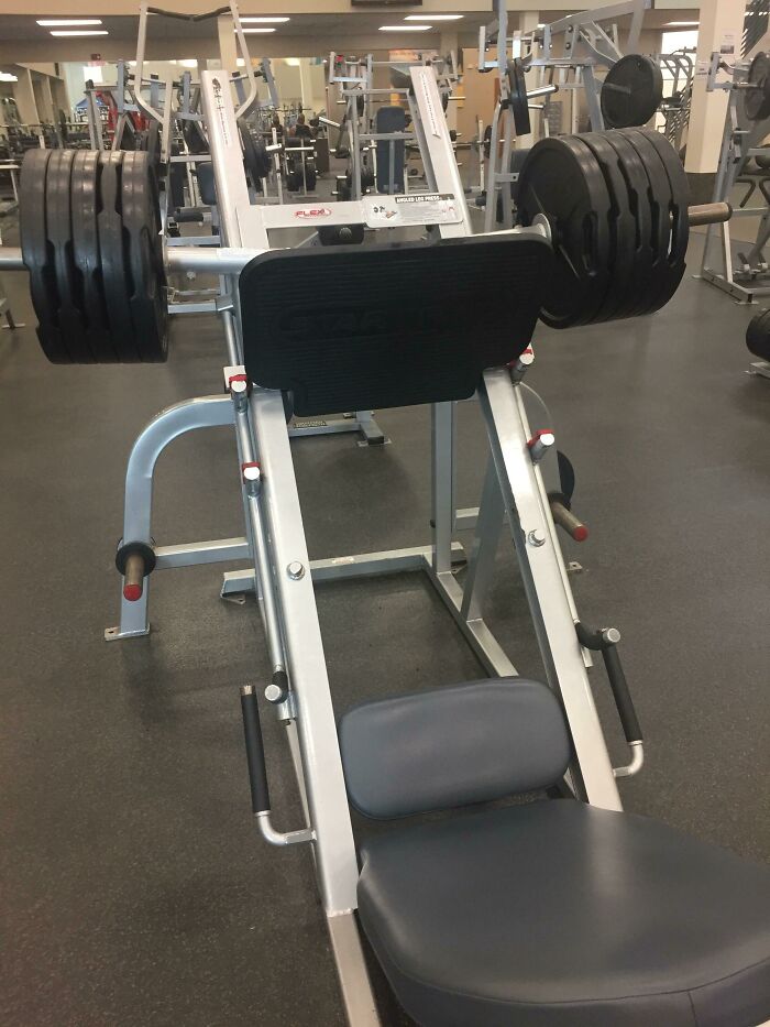 Gym weight machine overloaded with plates, illustrating lack of basic etiquette.