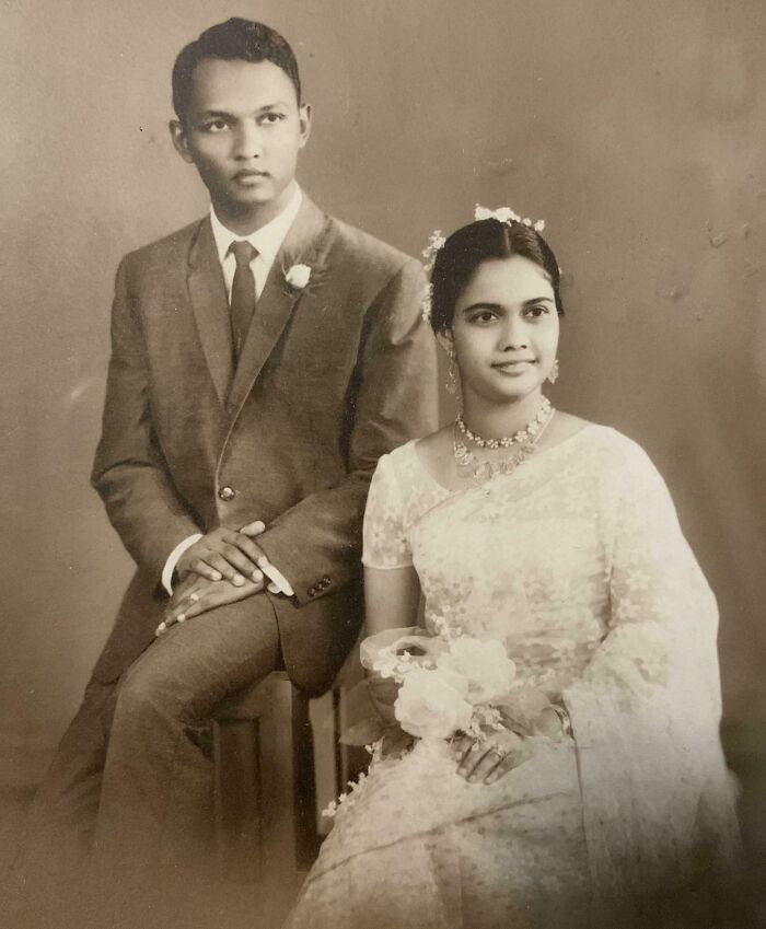 Vintage wedding photo of a couple, with the groom in a suit and the bride in a white sari holding a bouquet.