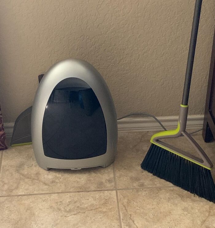 Smart home product next to a modern broom on a tile floor, offering affordability and innovation.