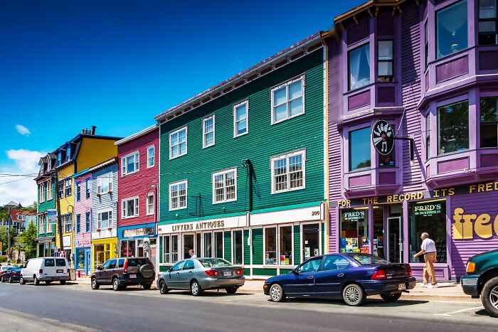 Colorful city with vibrant buildings and parked cars on a sunny day.