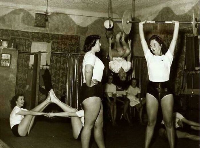 Women exercising in a vintage gym setting, showcasing historical fitness practices.