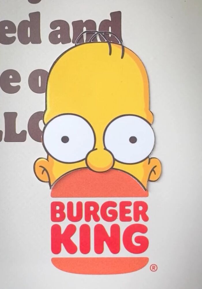Simpsons paper cutout of a character above a Burger King logo, blending art with real-world branding.